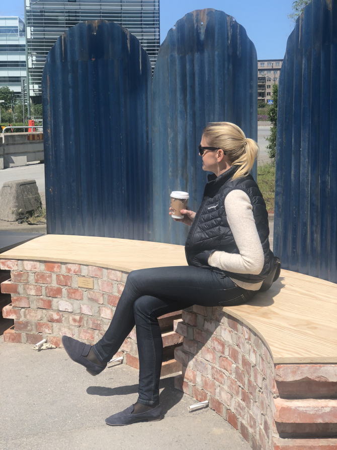 Hållbar bänk Varvsstaden Kvinna sitter på bänk med kaffekopp